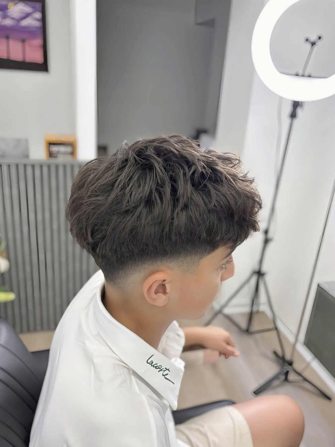 Kiểu tóc xoăn nhẹ fade hai bên, chụp từ góc khác