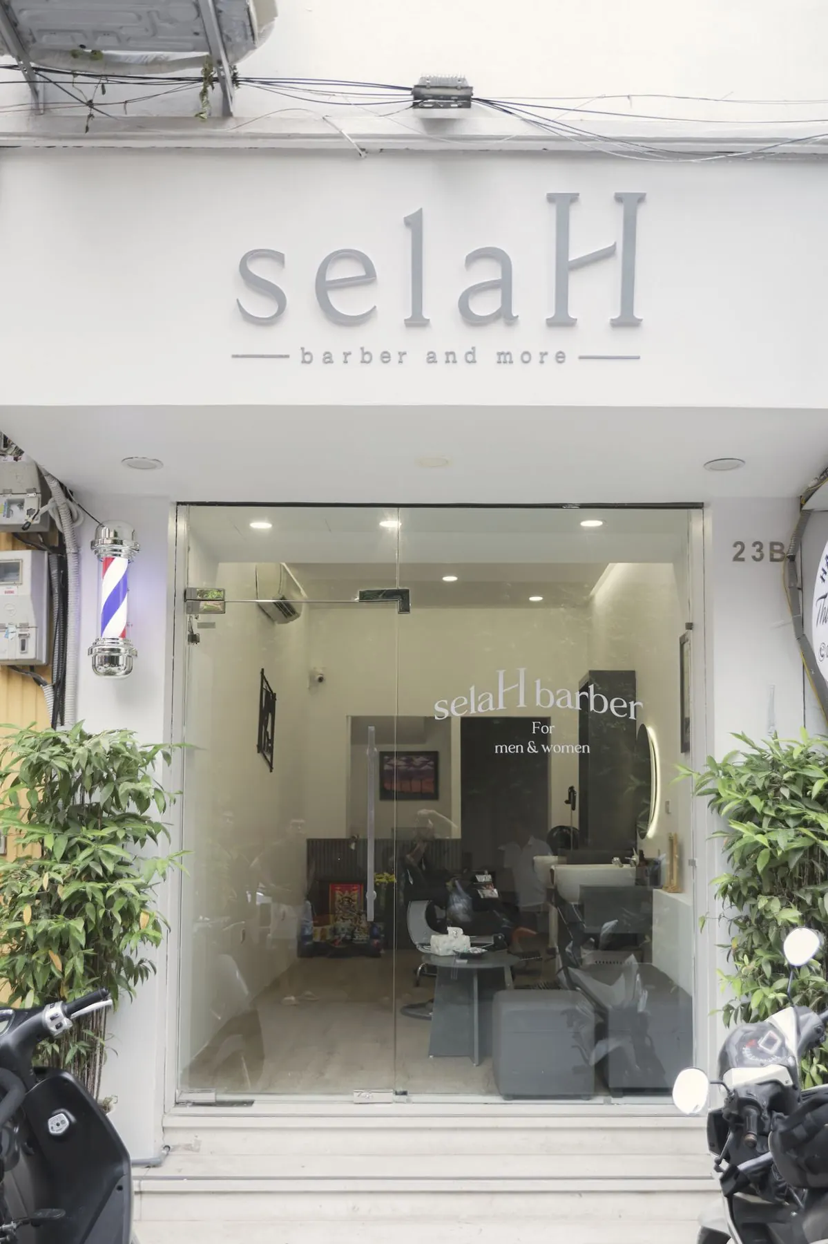Mặt tiền tiệm selaH với cột barber pole và cửa kính