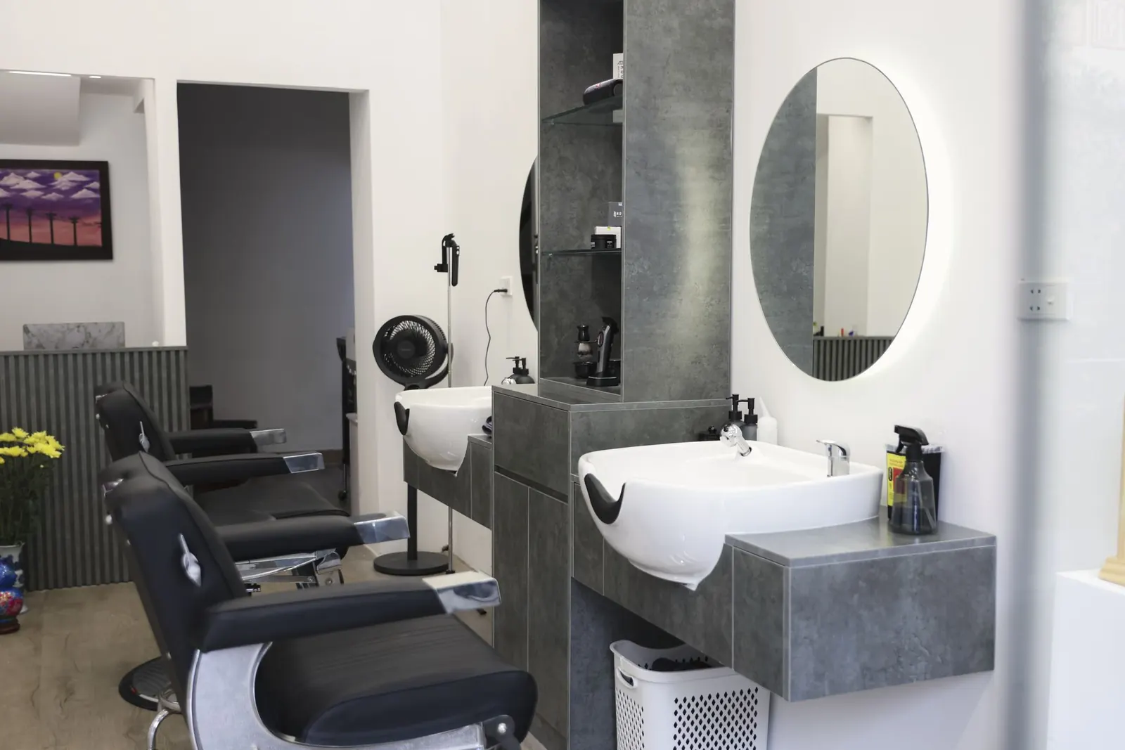 Ghế barber và chậu gội trong không gian tường trắng của tiệm